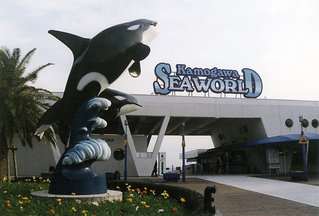 鴨川シーワールド | ELEMOs Orca statue leaping from a blue wave in front of the Kamogawa Seaworld entrance signage.