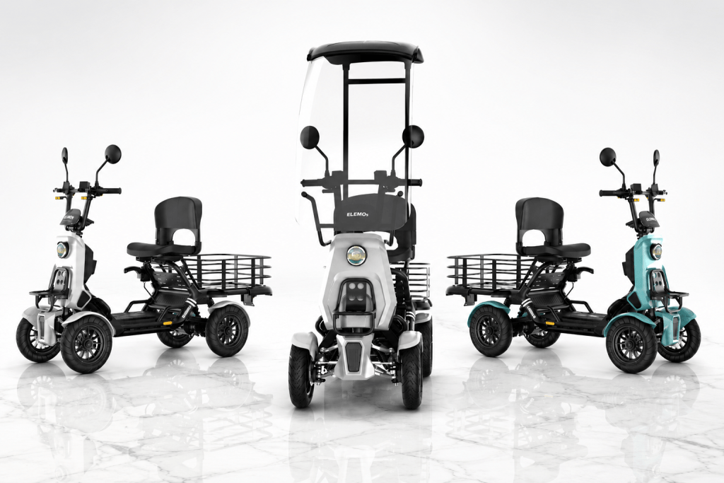 Three electric cargo trikes with rear baskets and a tall canopy, shown in a white studio setting. Central unit is front-facing with windshield.