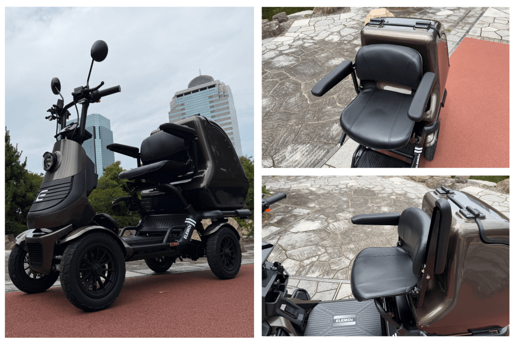 Brown three-wheeled mobility scooter parked on red pavement, showing handlebars, seat, and footboard with'ELEMOS' branding; urban buildings in background (informative product photo).